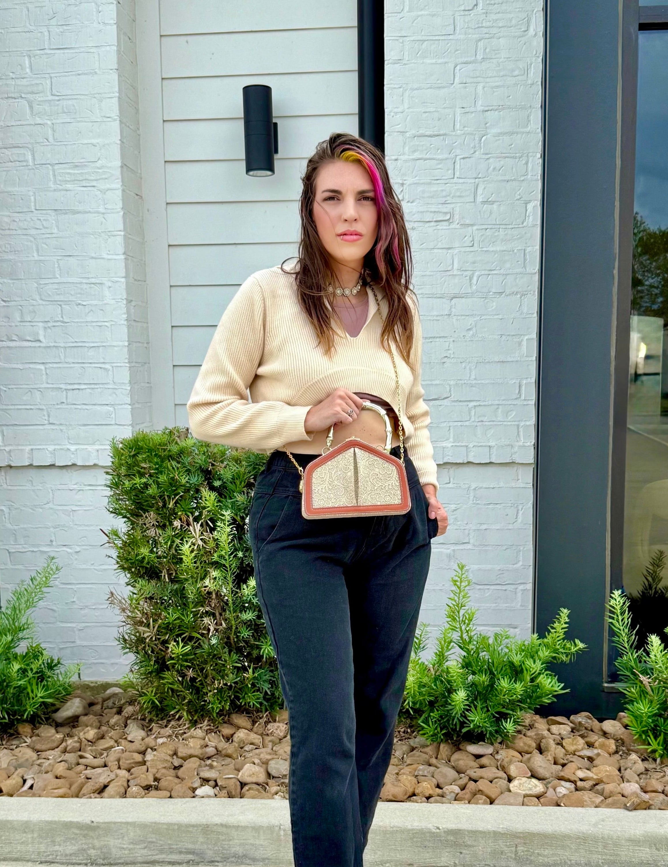 Woman standing outdoors holding a the JACE LEVON Victoria bag.