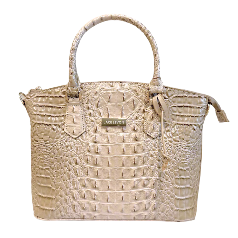 Beige crocodile-patterned handbag with a visible brand label on a light background
